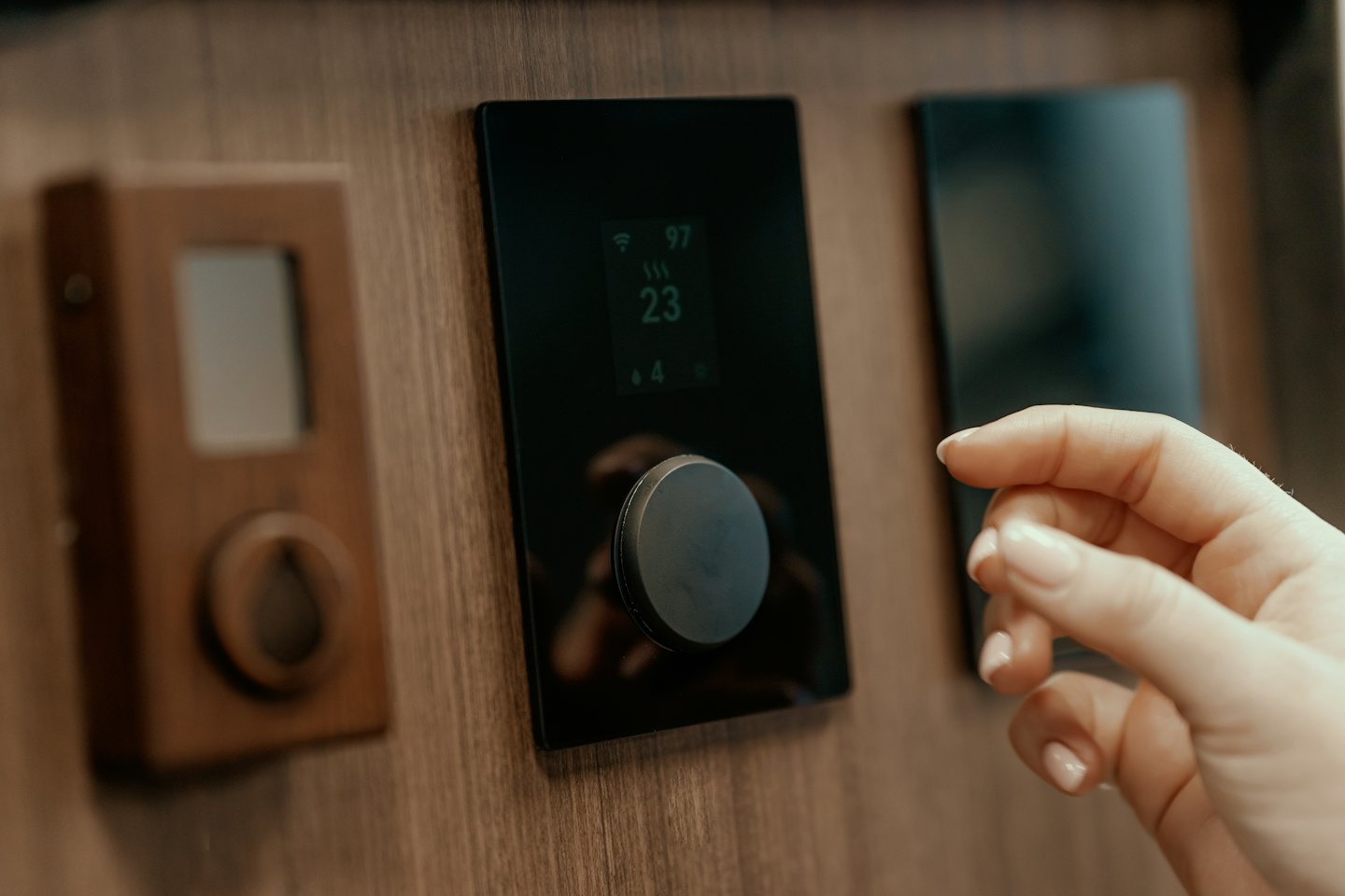 Hand bedient Smart-Home-Bedienfeld an Holzwand.