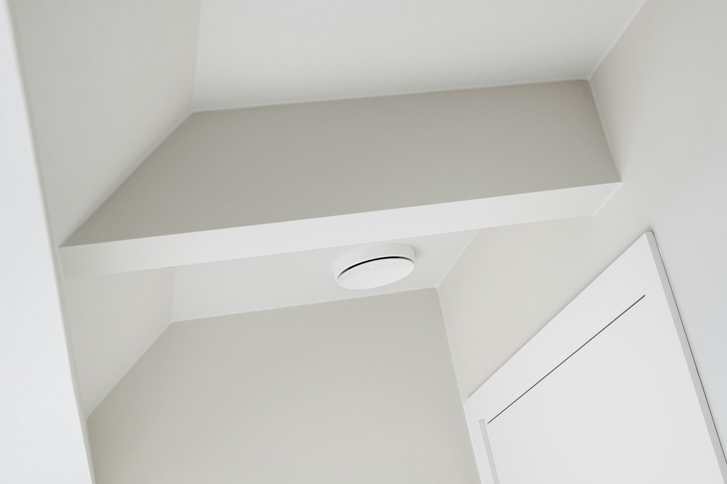 Ein weißes Smart-Home-Gerät ist an der Decke montiert.